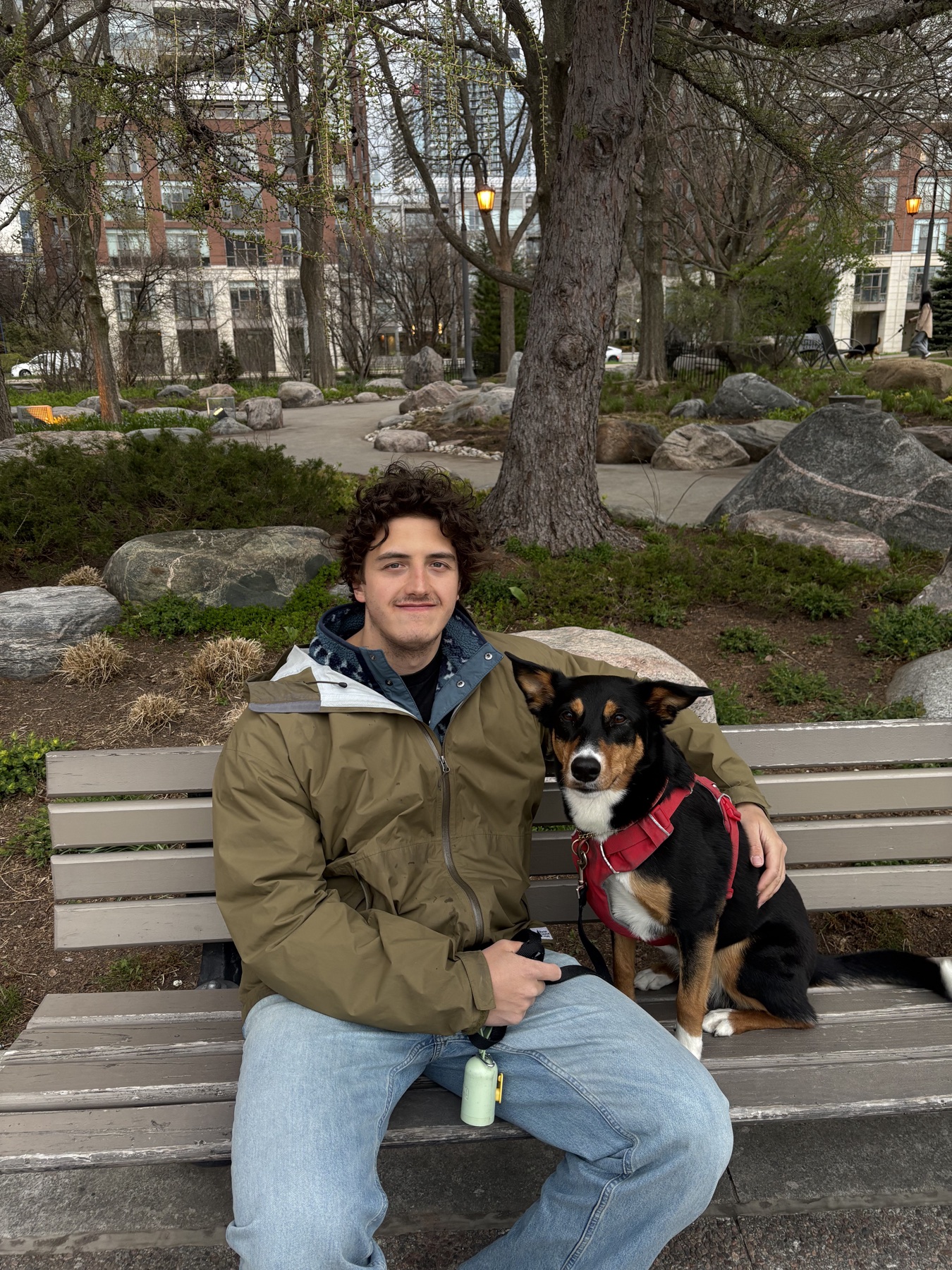 Blake Adams sitting on a park bench with a dog
